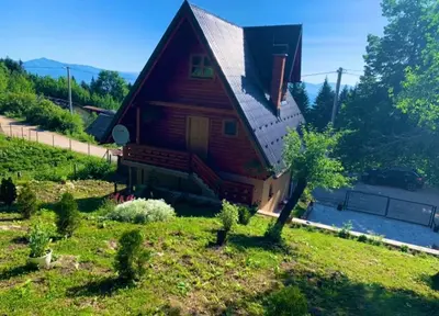 a log house with a porch and a yard at Planinska kuca za odmor-Mlinista in Landeke