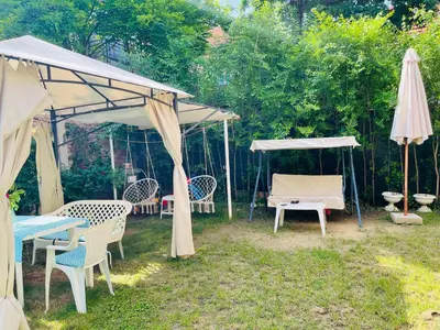 a group of tables and umbrellas in a yard at Apartman Indira in Visoko