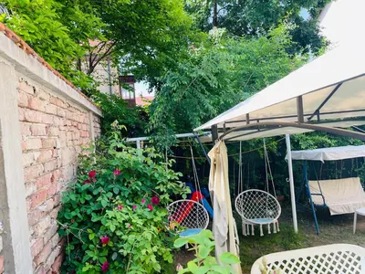 a patio with two chairs and an umbrella and flowers at Apartman Indira in Visoko