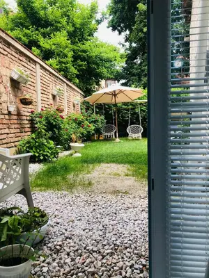 a patio with an umbrella and a table and bench at Apartman Indira in Visoko