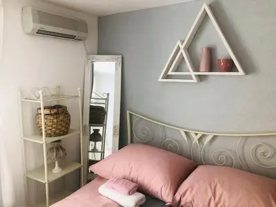 a bedroom with a pink bed and a mirror at Apartman Indira in Visoko