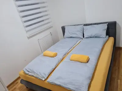 a bed in a room with two yellow pillows on it at Apartman Mirabell, Doboj in Doboj