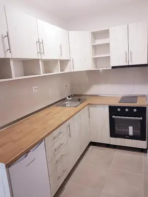 a kitchen with white cabinets and a sink at Apartman Mirabell, Doboj in Doboj