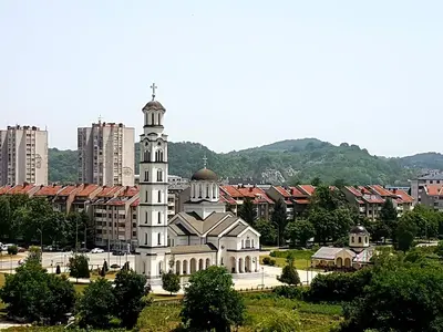 a building with a tower in front of a city at Apartman Mirabell, Doboj in Doboj