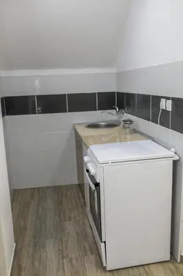 a small kitchen with a sink and a counter at Aparthouse Bilic in Jajce