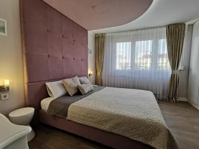 a bedroom with a large bed and a large window at Lux Apartment with Sauna & Balcony in Banja Luka