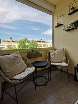two chairs and a table on a balcony with a window at Lux Apartment with Sauna & Balcony in Banja Luka