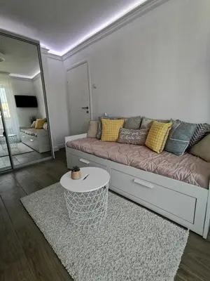 a living room with a couch and a mirror at Lux Apartment with Sauna & Balcony in Banja Luka