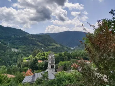 a building in the middle of a valley with mountains at MIMA in Jajce