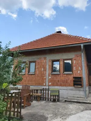 a brick house with a picnic table and chairs at MIMA in Jajce