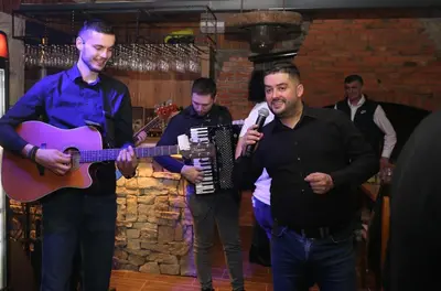 a group of men playing music and a man holding a guitar at Stone room-Kamena soba in Šipovo