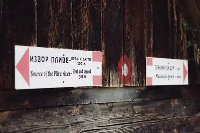 a couple of signs on a wooden fence at Stone room-Kamena soba in Šipovo