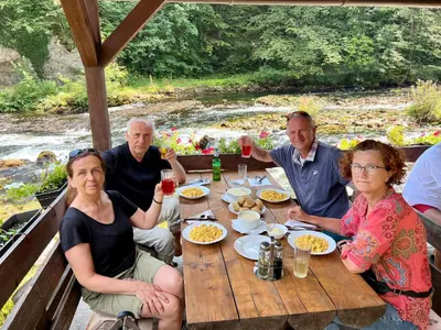 a group of people sitting around a wooden table at Stone room-Kamena soba in Šipovo