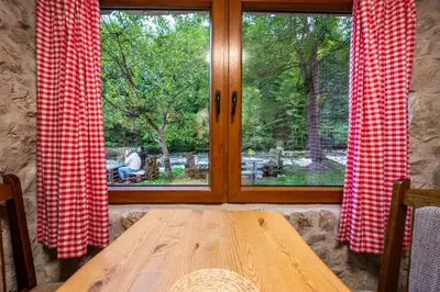 a wooden table sitting in front of a window at Stone room-Kamena soba in Šipovo