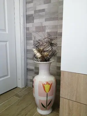 a vase with a flower on the floor next to a door at Studio Apartman Sun in Jajce
