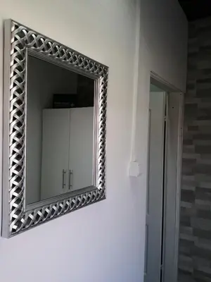 a mirror hanging on a wall in a bathroom at Studio Apartman Sun in Jajce