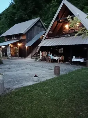 a barn with a table and chairs in front of it at Apartmani Dada Kanjon Grmuša in Bihać