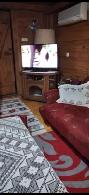 a living room with a red couch and a television at Apartmani Dada Kanjon Grmuša in Bihać