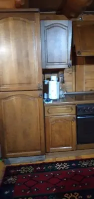 a kitchen with wooden cabinets and a sink and a stove at Apartmani Dada Kanjon Grmuša in Bihać