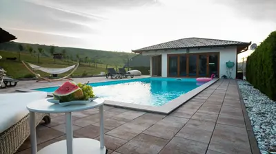 a house with a pool and a table with a watermelon on it at Villa De Luxe in Bihać