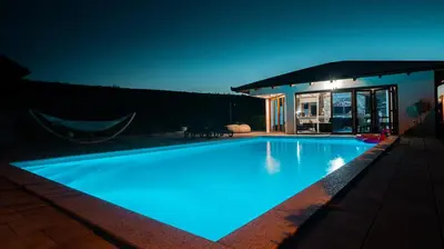 a swimming pool at night with blue lights at Villa De Luxe in Bihać