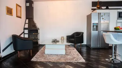 a living room with a stove and two chairs at Villa De Luxe in Bihać