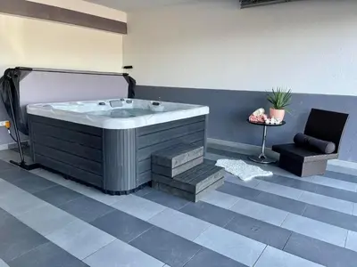a jacuzzi tub in a room with a chair at Villa De Luxe in Bihać
