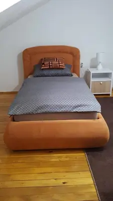 a bed in a bedroom with a wooden bed frame at Apartman 