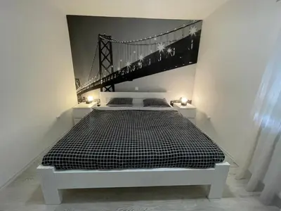 a bedroom with a bed with a bridge on the wall at Apartman Kis in Jajce