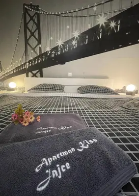 a bed with a blanket in front of a bridge at Apartman Kis in Jajce