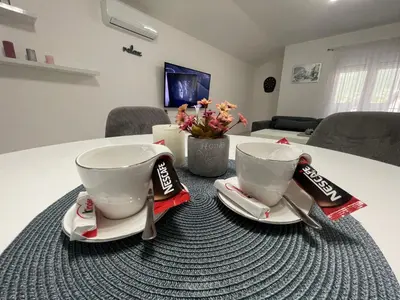 two cups sitting on plates on a table at Apartman Kis in Jajce