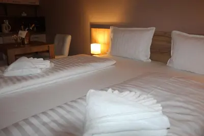 a bedroom with two beds with white sheets and pillows at Apartmani Kakanj in Kakanj