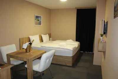 a bedroom with a bed and a table and a table and chairs at Apartmani Kakanj in Kakanj