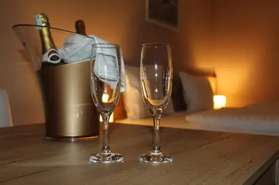 two wine glasses sitting on a wooden table at Apartmani Kakanj in Kakanj