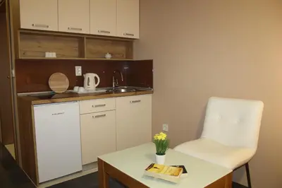 a kitchen with a white chair and a table at Apartmani Kakanj in Kakanj