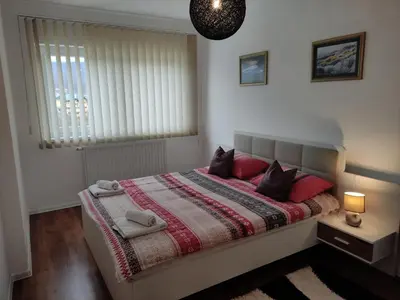 a bedroom with a bed with two black cats on it at Apartman ALEM Bihac in Bihać