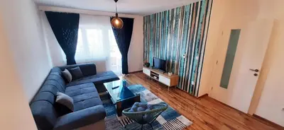 a living room with a blue couch and a tv at Apartman ALEM Bihac in Bihać