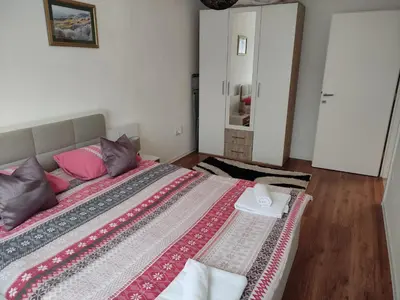 a bedroom with a large bed with pink pillows at Apartman ALEM Bihac in Bihać
