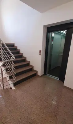a staircase in an office building with a glass door at Apartman ALEM Bihac in Bihać