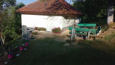 a small building with a green bench in front of it at Family house in Visoko