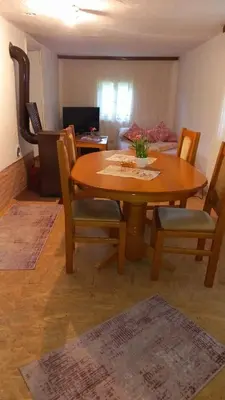 a wooden table and chairs in a living room at Family house in Visoko