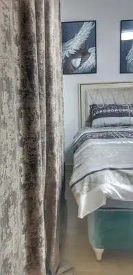 a bedroom with a bed with a curtain next to it at Intime by Nights & Smiles in Tuzla