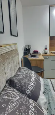 a hotel room with a bed and a kitchen at Intime by Nights & Smiles in Tuzla
