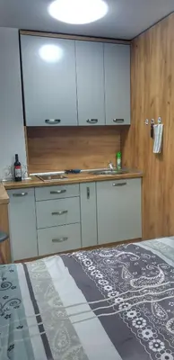 a kitchen with white cabinets and a counter top at Intime by Nights & Smiles in Tuzla