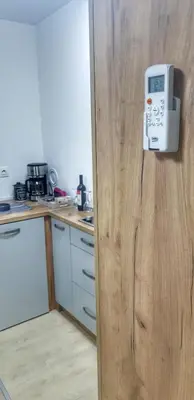 a kitchen with a refrigerator with a microwave on the door at Intime by Nights & Smiles in Tuzla