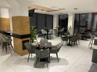 a restaurant with tables and chairs in a building at Belamionix motel in Bosanski Šamac