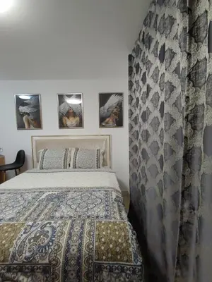 a bedroom with a bed and some pictures on the wall at Skyline by Nights & Smiles in Tuzla