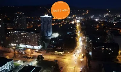 a city at night with a sign that reads trust and mind at Skyline by Nights & Smiles in Tuzla