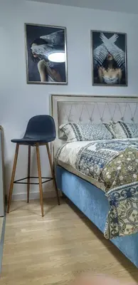 a bedroom with a bed and a chair in it at Skyline by Nights & Smiles in Tuzla