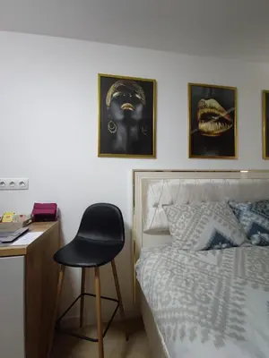 a bedroom with a bed and a chair next to a desk at Identity By Nights & Smiles in Tuzla